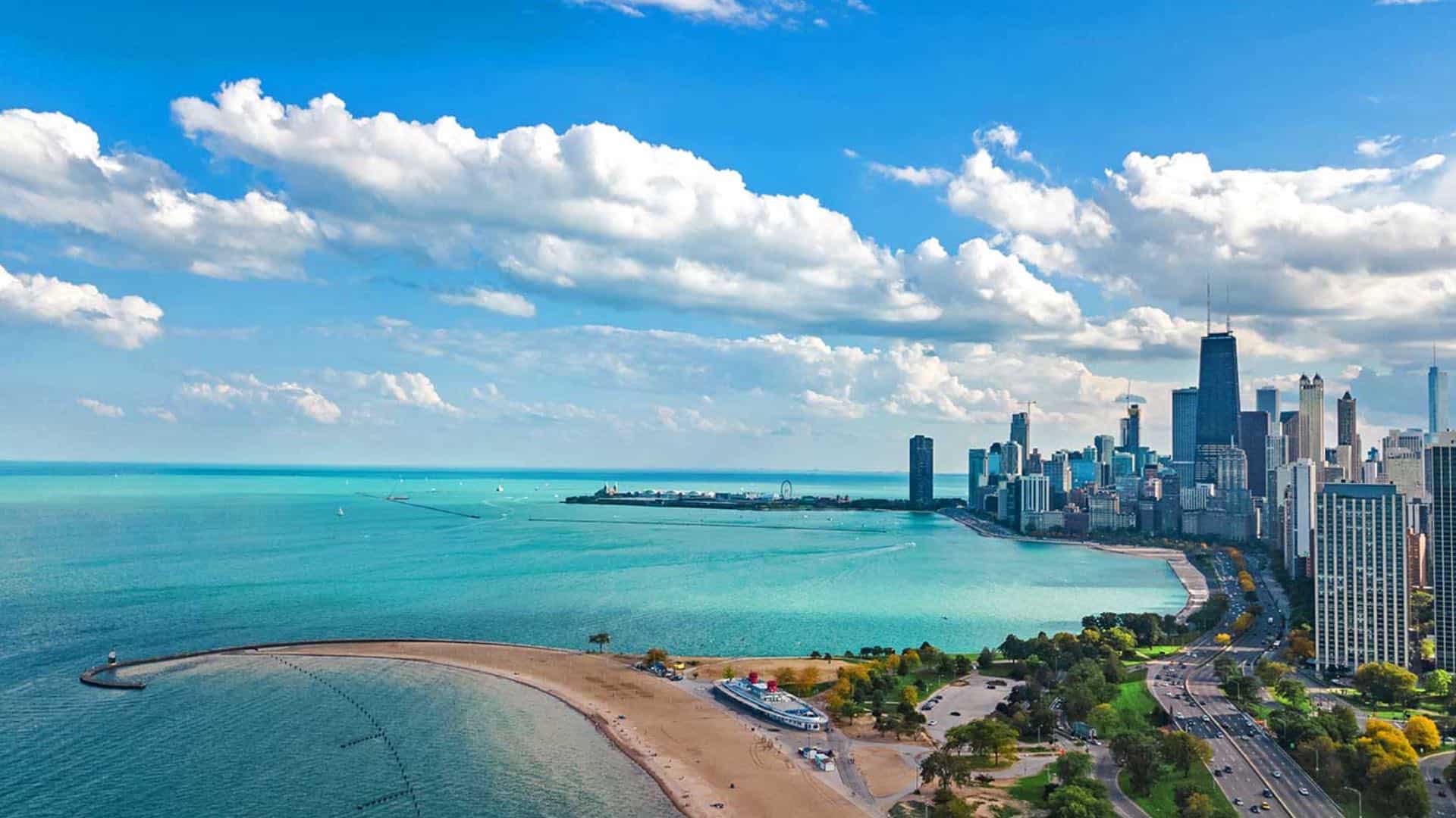 Aerial view of a downtown city with a large pier out into light blue water