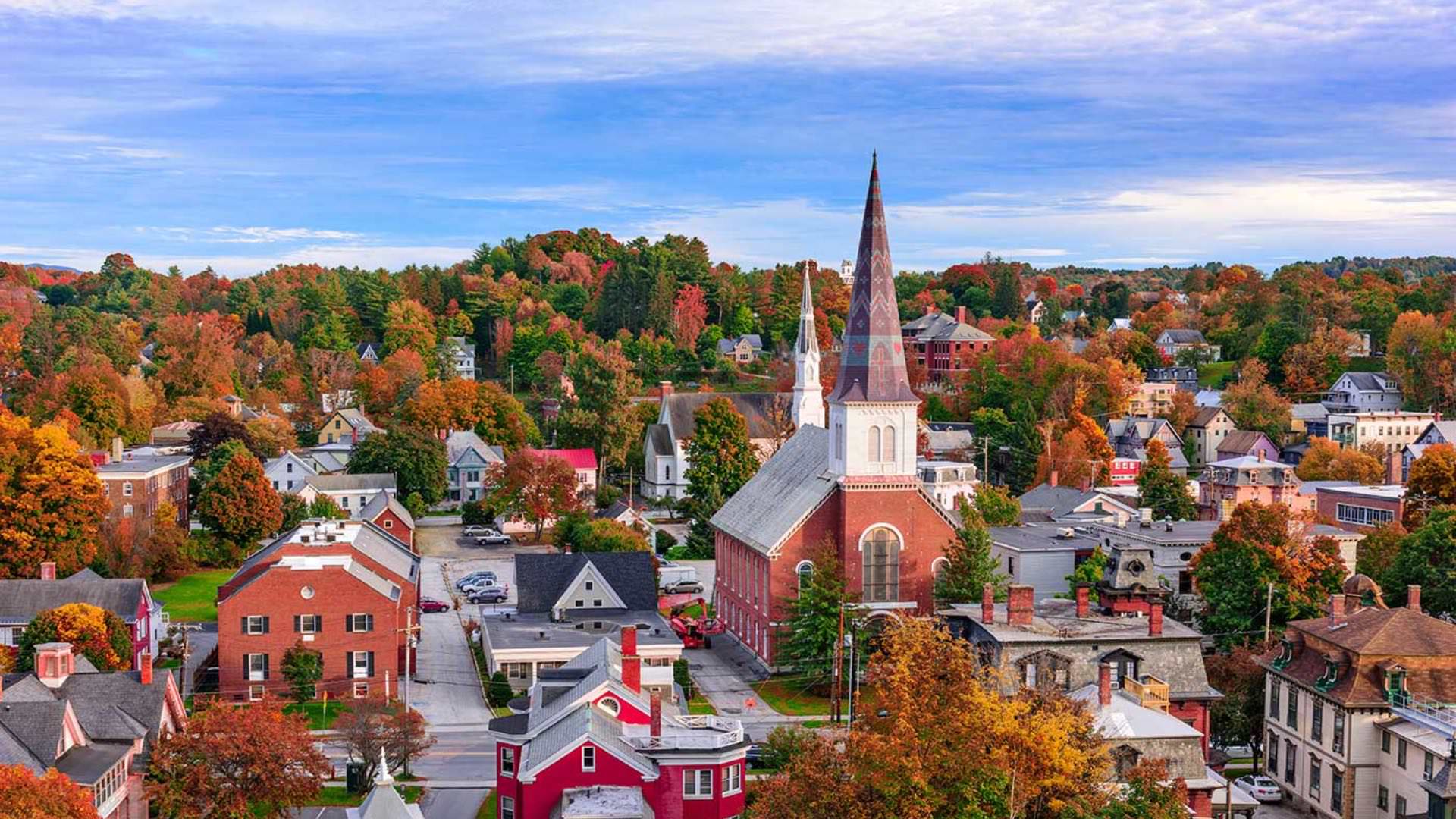 Aerial view of small town area with red, orange, and green trees